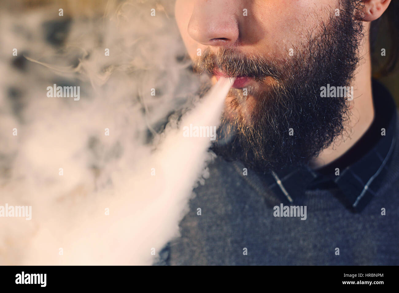 Männer mit Bart Dampfen und löst eine Wolke aus Dampf. Stockfoto