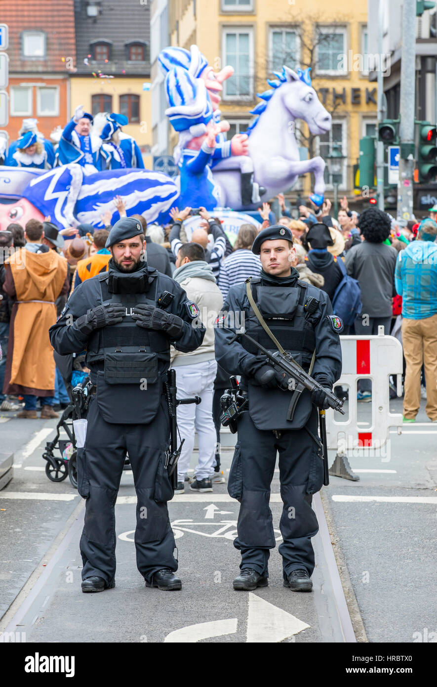 Deutsche Karnevalsumzug in Düsseldorf, Polizisten sichern die Parade blockieren Straßen mit LKW vor terroristischen Anschlägen mit Fahrzeugen, Stockfoto