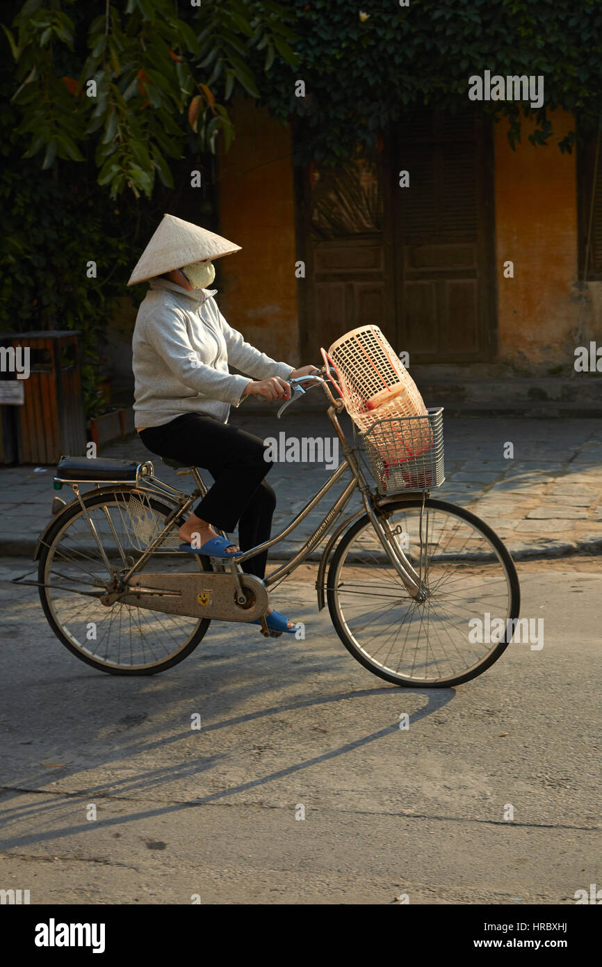 Vietnamesin mit kegelförmiger Hut auf Fahrrad, Hoi an ein (UNESCO Weltkulturerbe), Vietnam Stockfoto