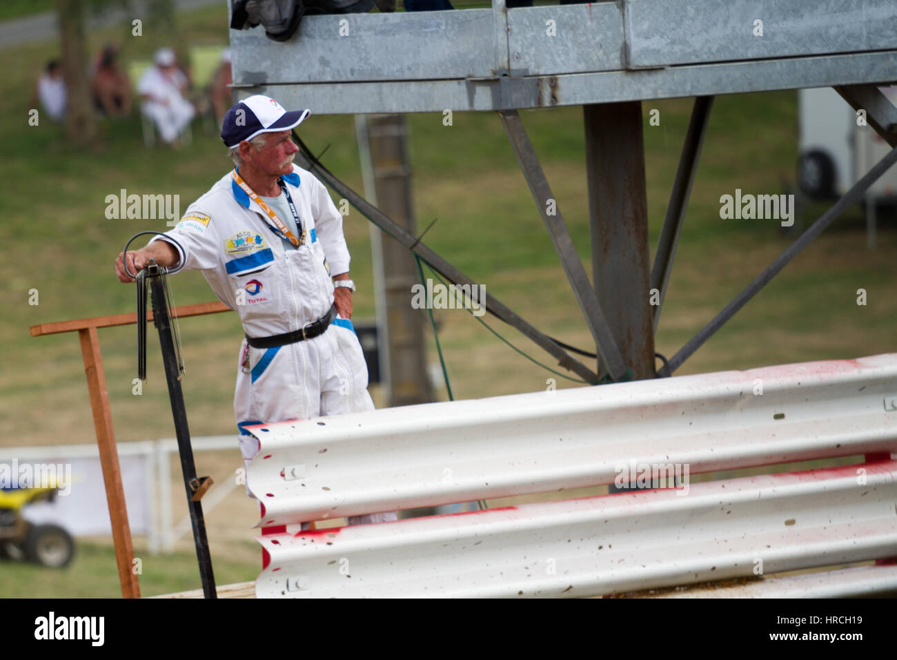 Autocross-Service-Mann im weiß-blauen Uniform beobachten das Rennen wegschauen Stockfoto