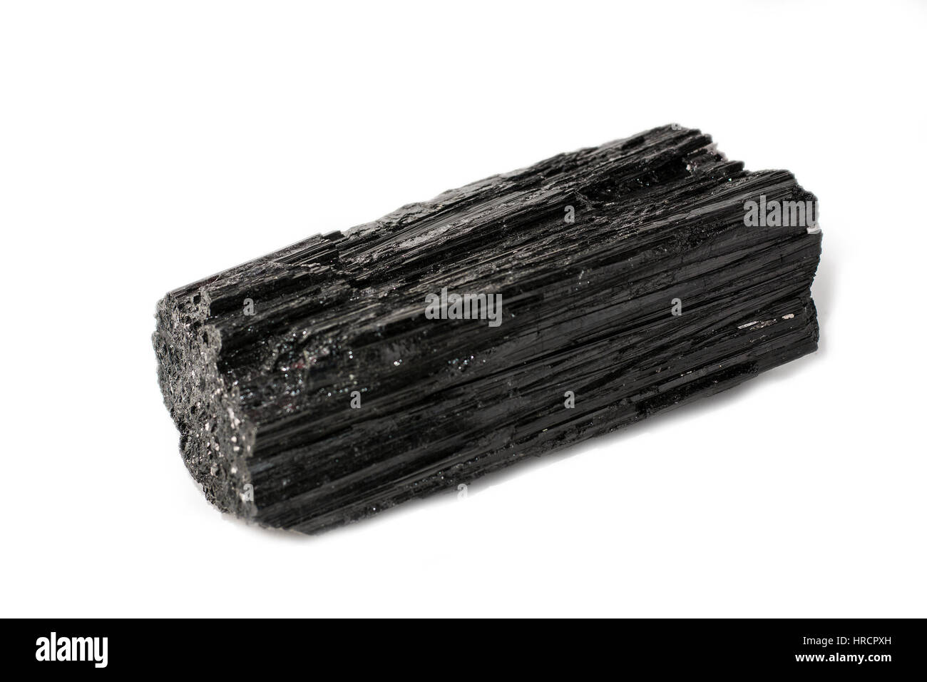 Schwarzer Turmalin Stein platziert auf dem weißen Hintergrund. Horizontale Studio gedreht. Stockfoto