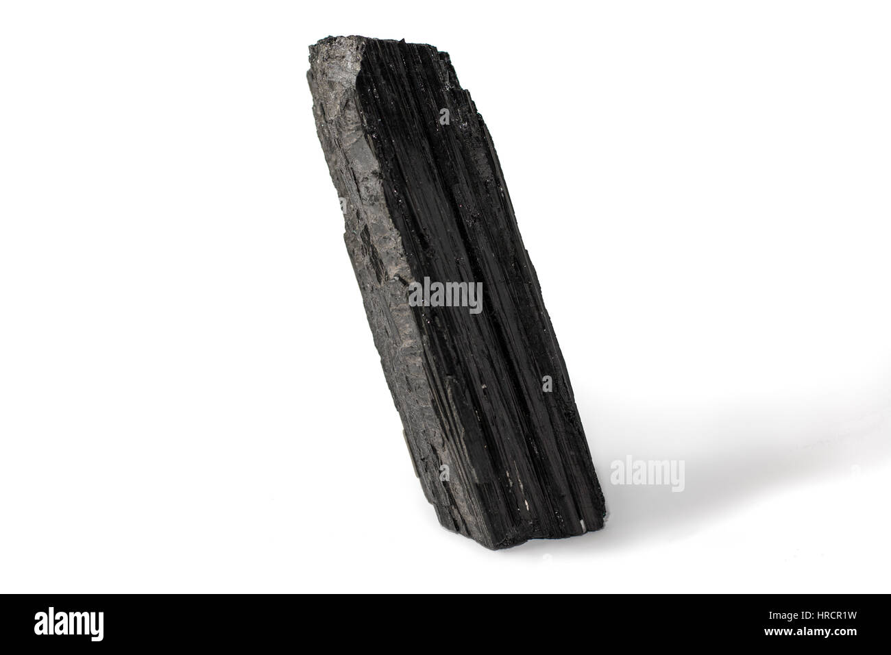 Schwarzer Turmalin Stein platziert auf dem weißen Hintergrund. Horizontale Studio gedreht. Stockfoto