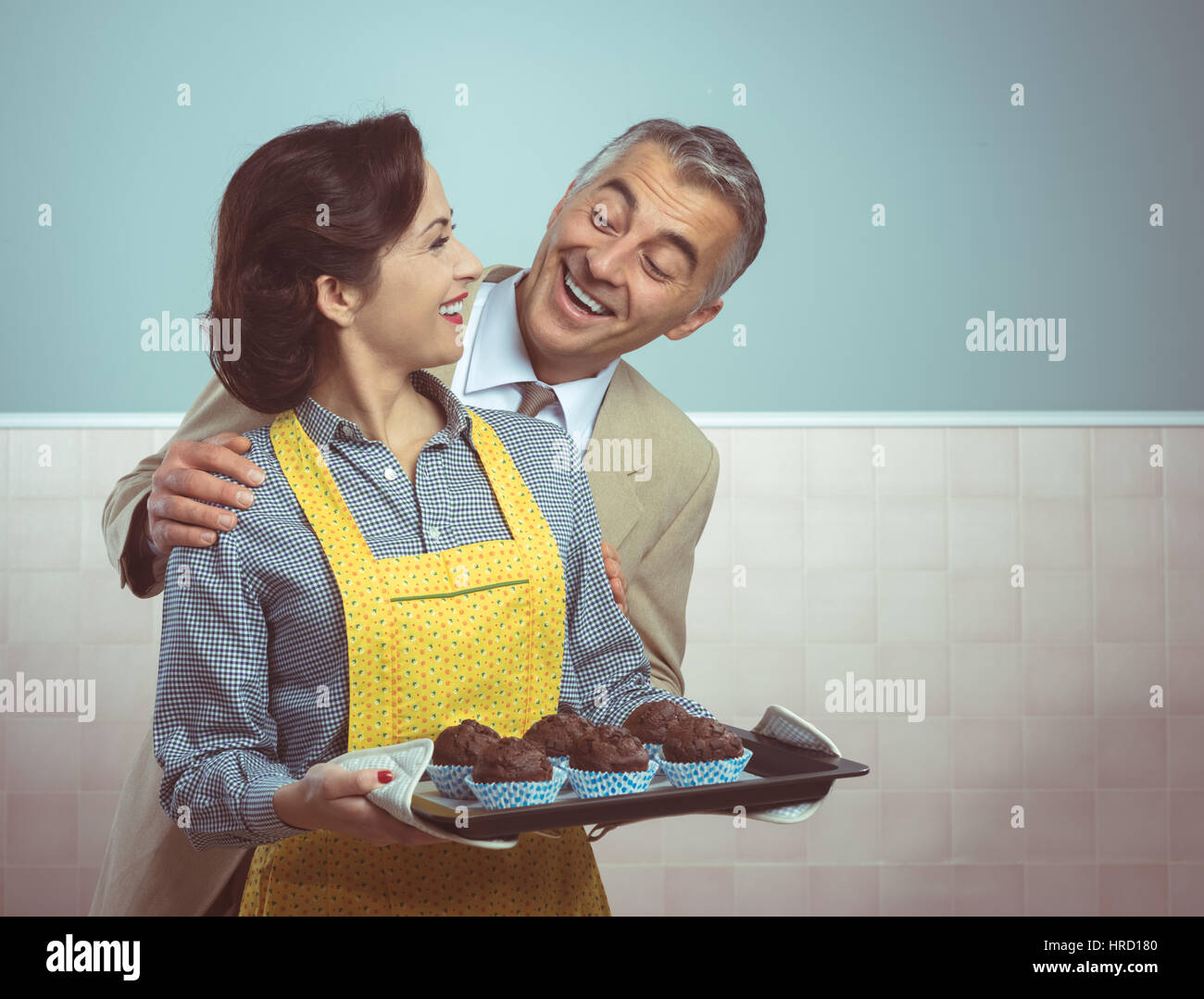 Vintage Frau in Schürze Kochen Schokolade Muffins für ihren Mann Stockfoto