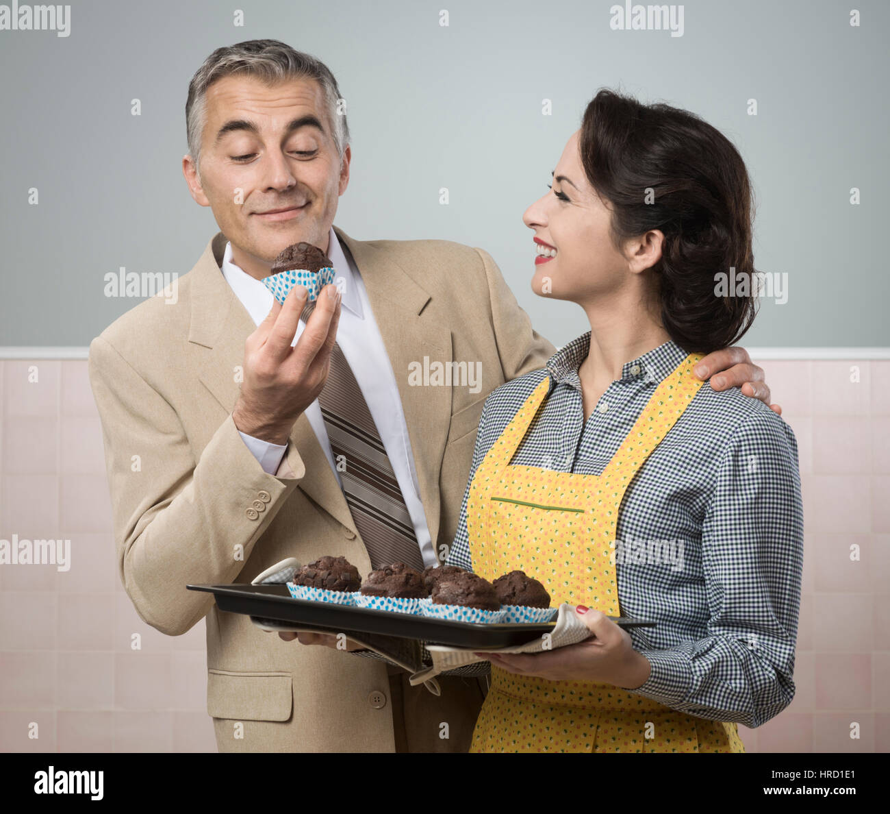 Vintage Frau in Schürze Kochen Schokolade Muffins für ihren Mann Stockfoto