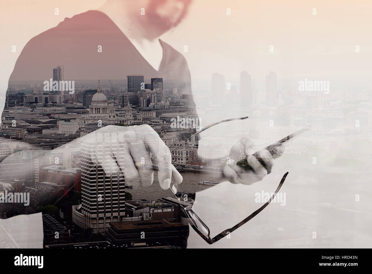 Doppelbelichtung von Designer-Hand mit Brillen, mit Smartphone, London Architektur Stadt Stockfoto