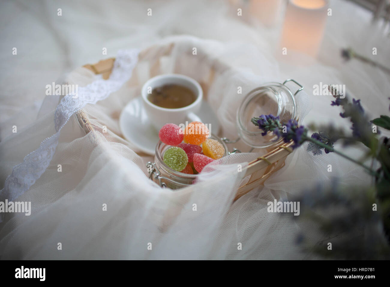 Tasse Tee und Marmelade in ein Glas legen in den Warenkorb mit einem weißen Seidentuch bedeckt Stockfoto