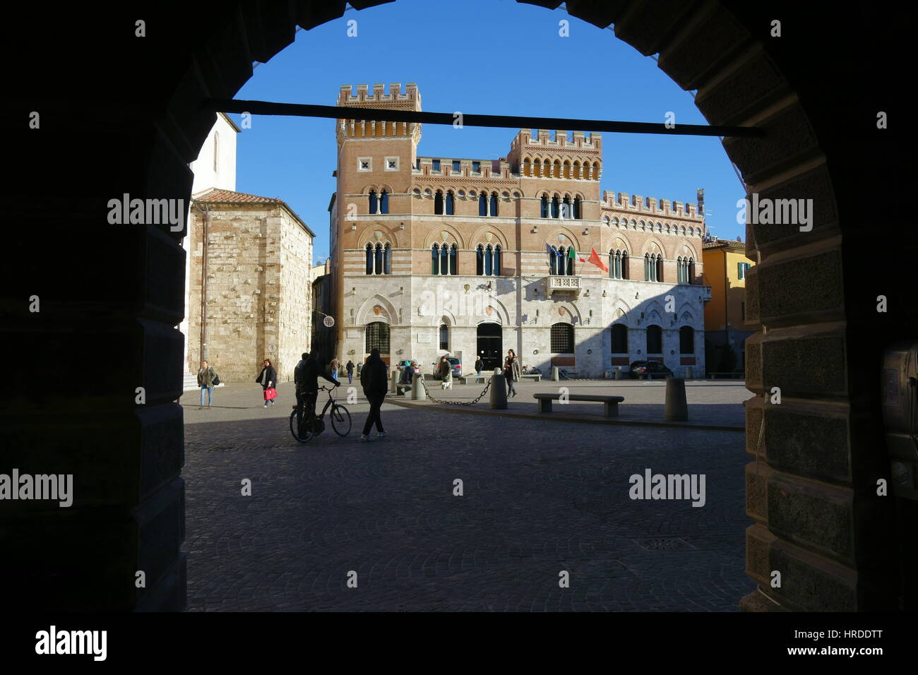 Grosseto Palazzo Aldobrandeschi Fassade Blick durch einen Bogen vor einem strahlend blauen Himmel - Piazza Dante Alighieri, Grosseto, Toskana, Italien, Europa Stockfoto