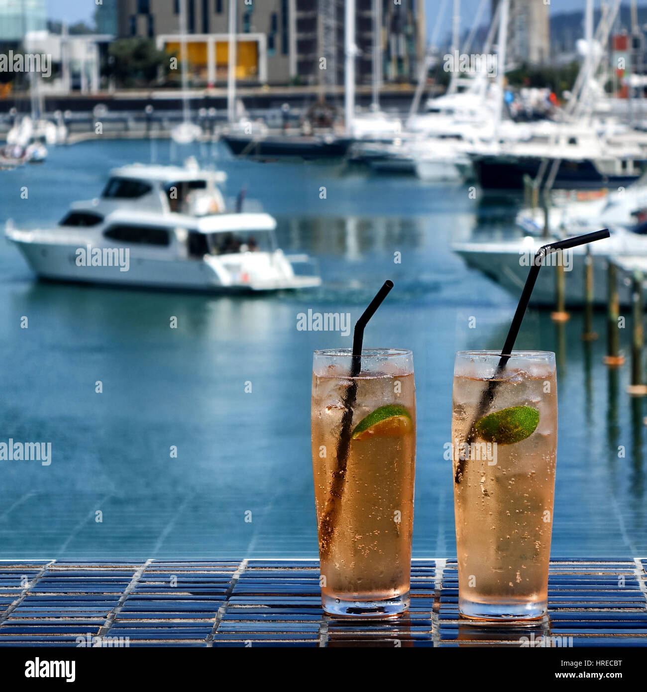 Kalte Kalk Getränke in Gläsern auf dunklen Tisch im Freien mit Hafen im Hintergrund Stockfoto