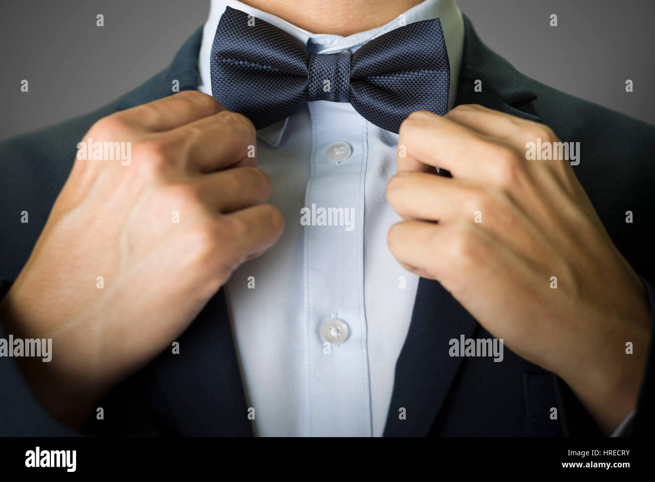 Ein Mann im dunkelblauen Anzug und Fliege hautnah Stockfoto