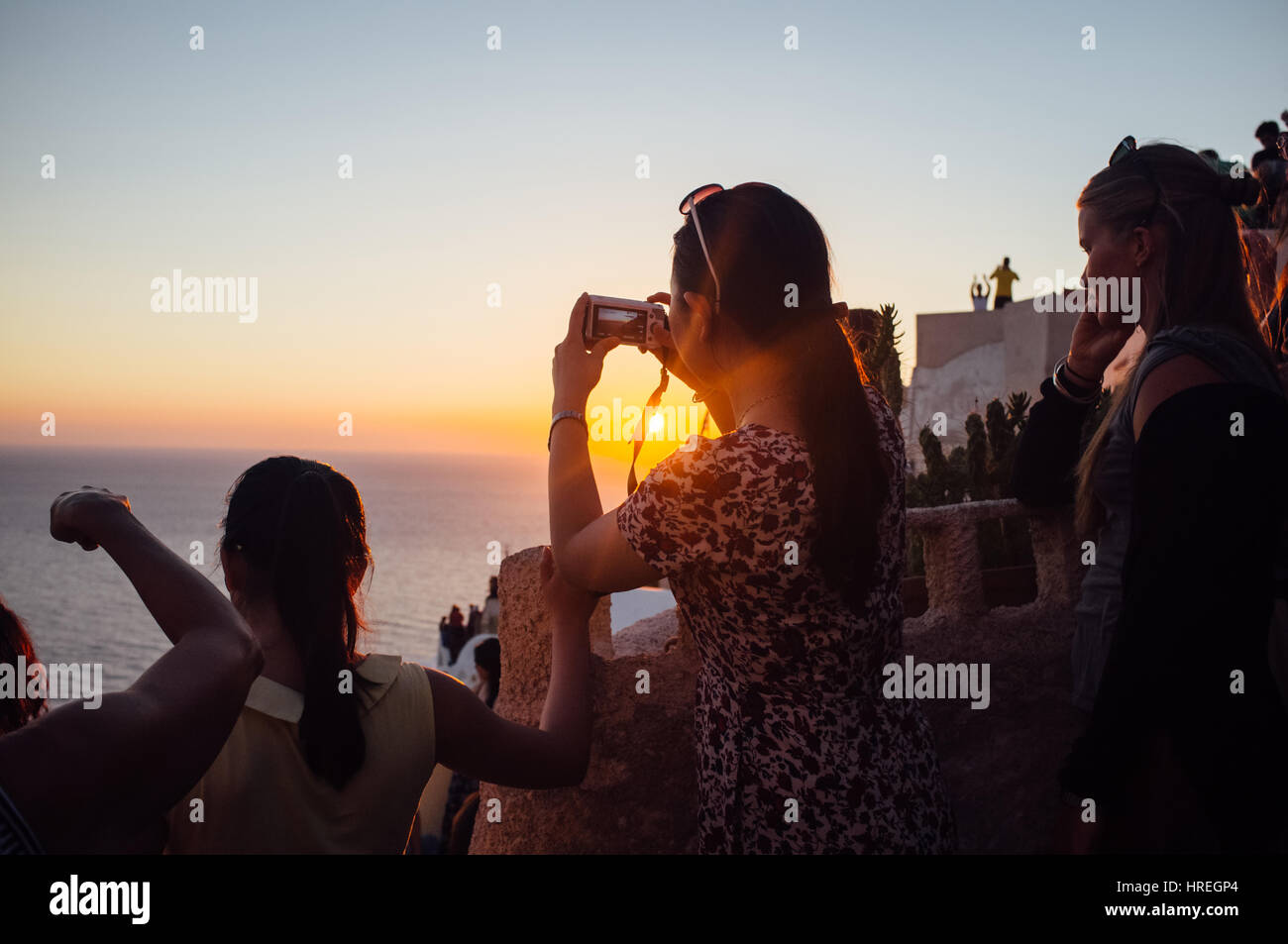 Touristen beobachten den Sonnenuntergang in schönen Santorini, Griechenland. Stockfoto