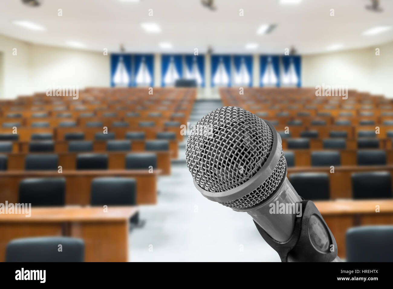 Mikrofon mit unscharfen Foto von leeren Saal oder Seminar Konferenzraum im Hintergrund. Business-Meeting-Konzept Stockfoto