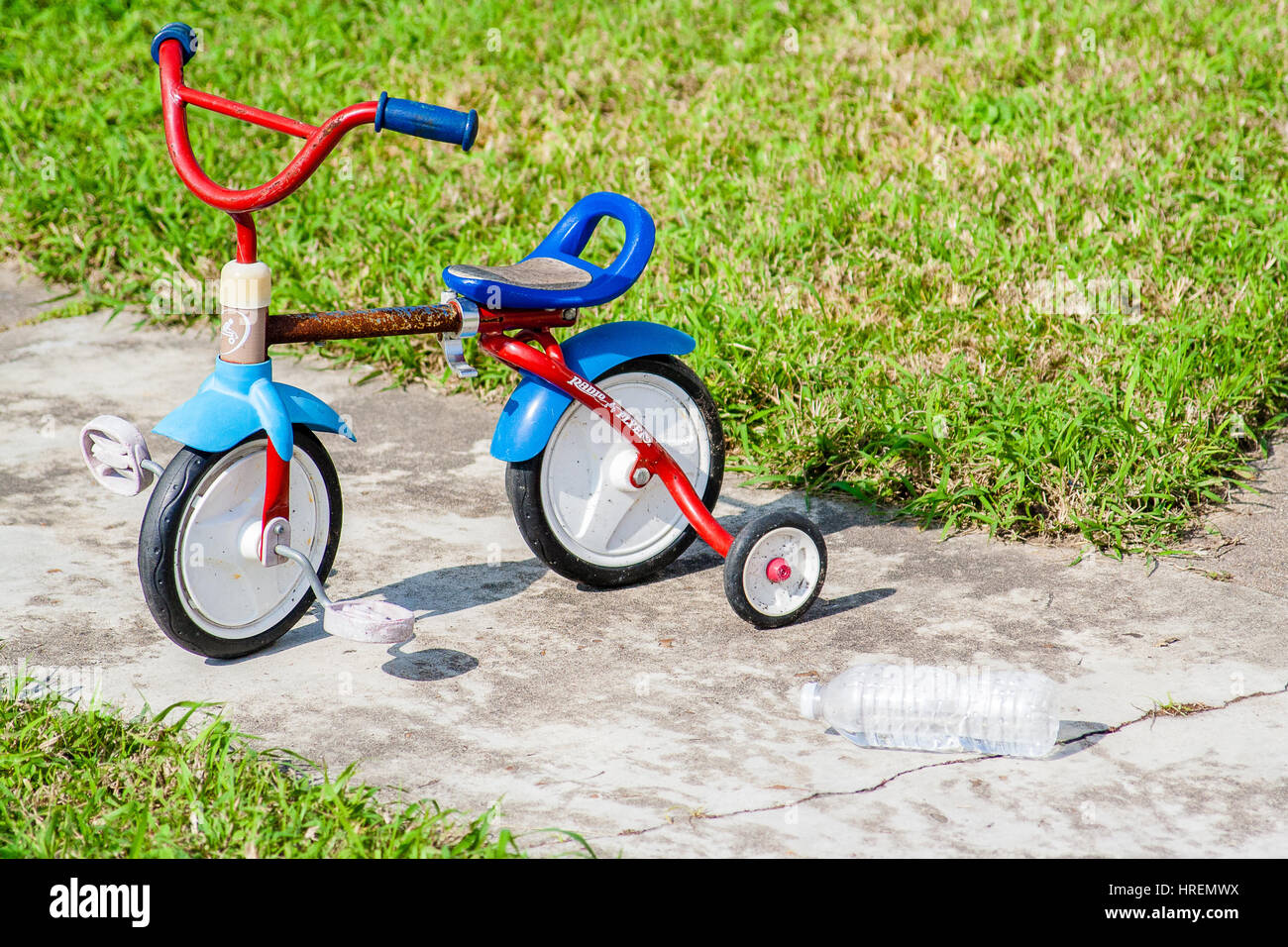 GALVESTON, TX, Januar 2017: Verlassenen Kleinkind Fahrrad mit Stützrädern und eine leere Wasserflasche suggestive einer vorherigen anstrengenden Fahrt Stockfoto