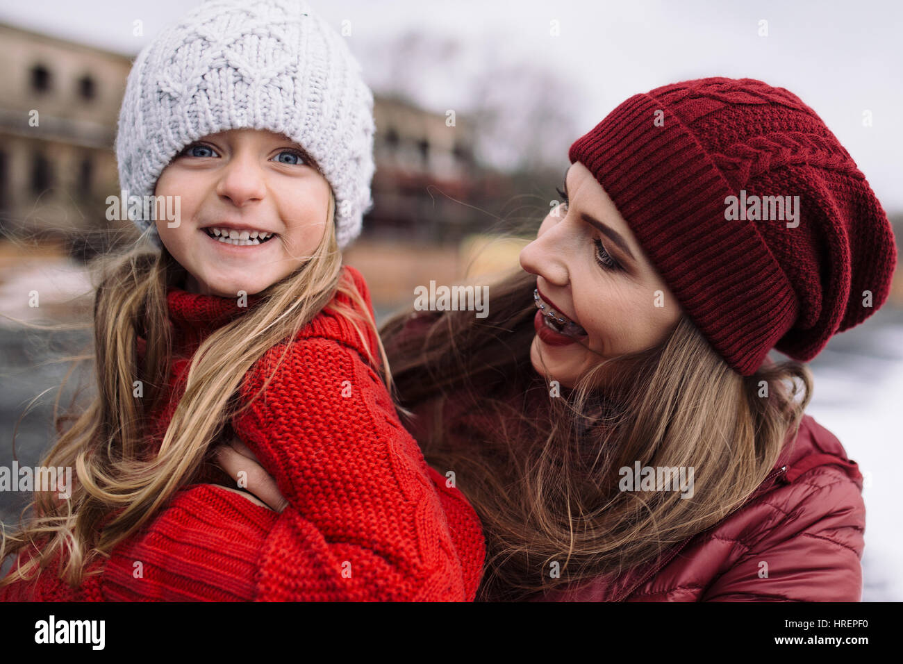 schöne junge Frau umarmt kleine Mädchen. Mutter und Tochter Leben im Freien genießen Stockfoto