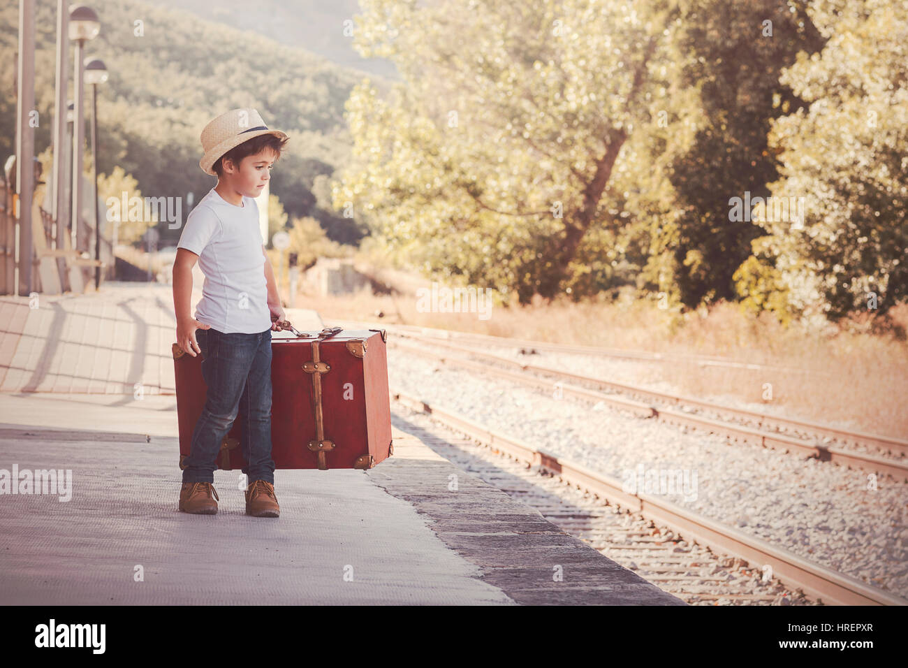 Junge mit Koffer warten auf den Zug Stockfoto