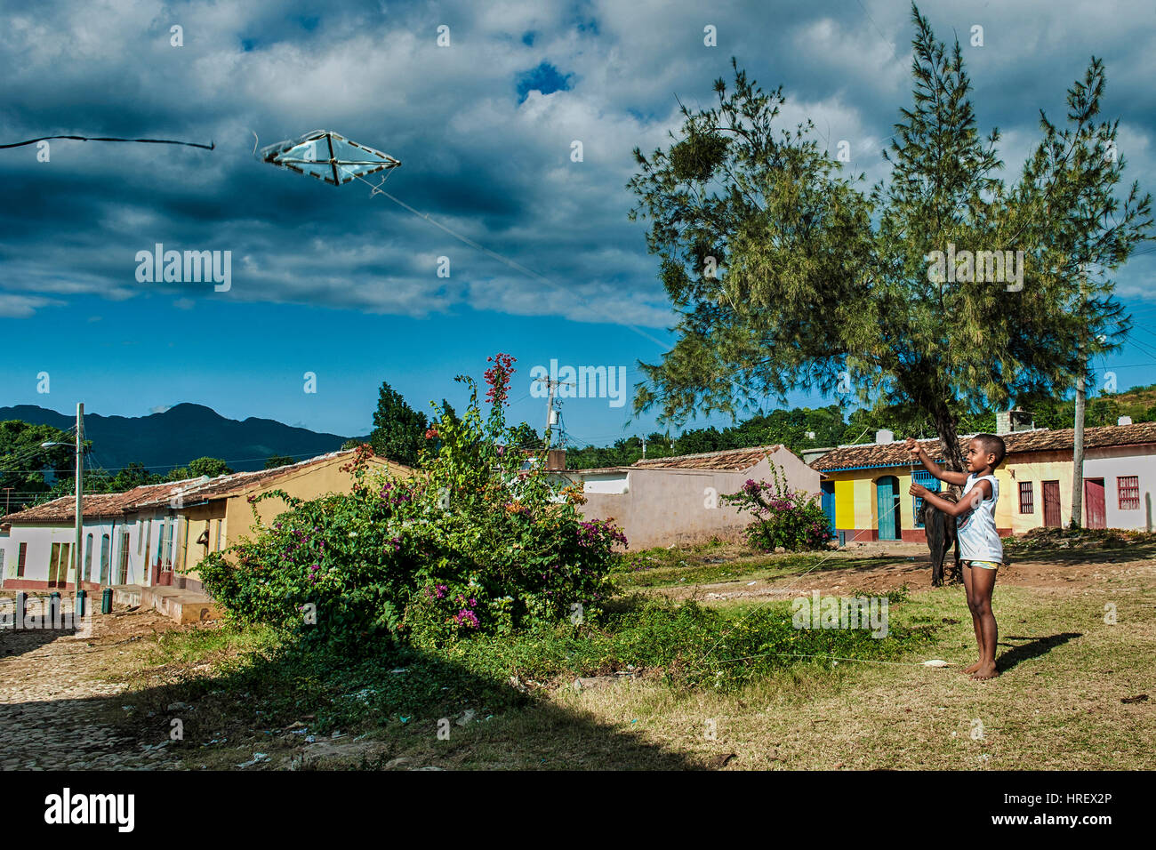 Ein Kind spielt mit seinem Kite in einem Garten am Stadtrand von Trinidad, Kuba Stockfoto