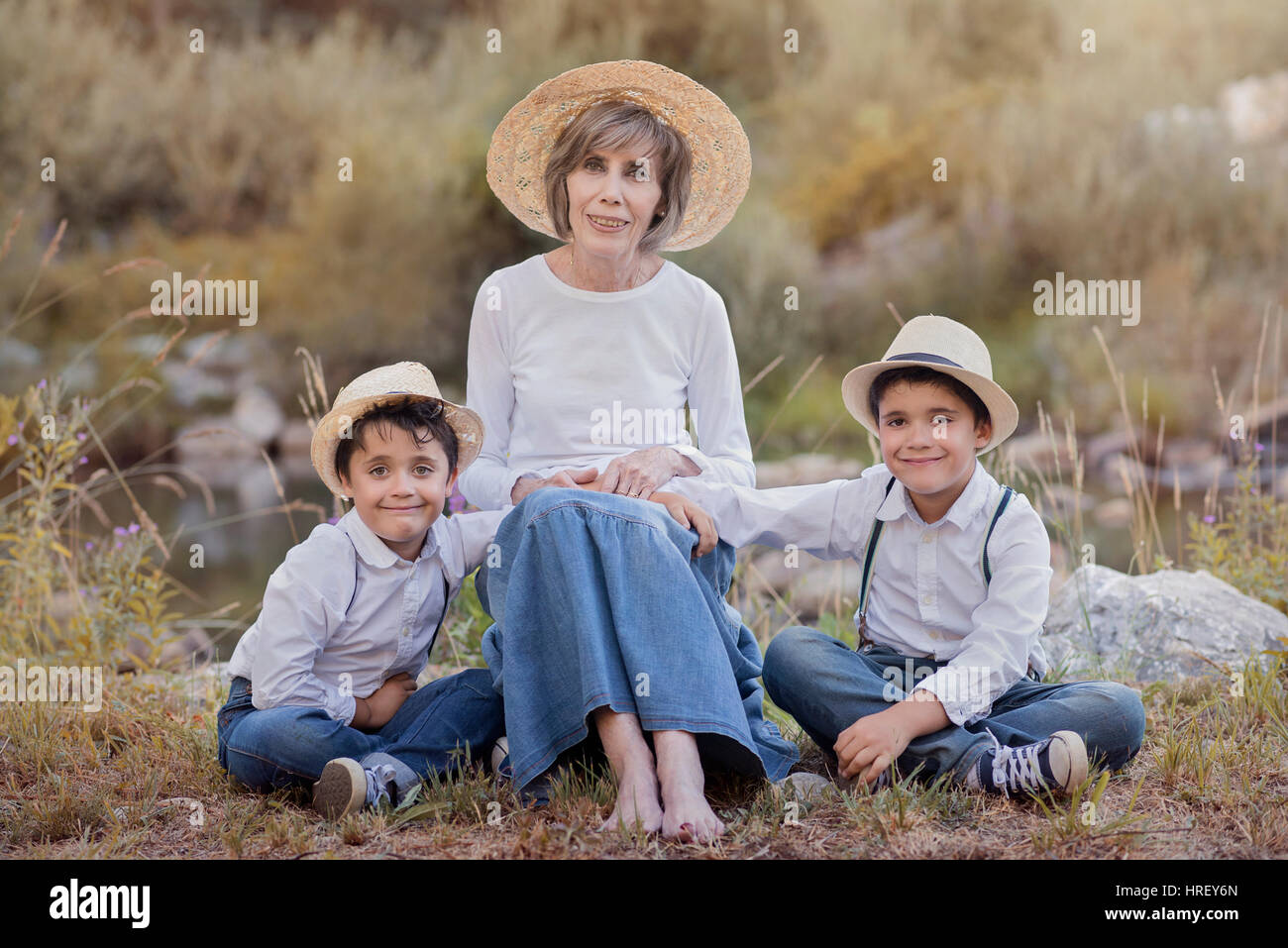 Oma mit ihrem Enkel sitzen im Feld Stockfoto