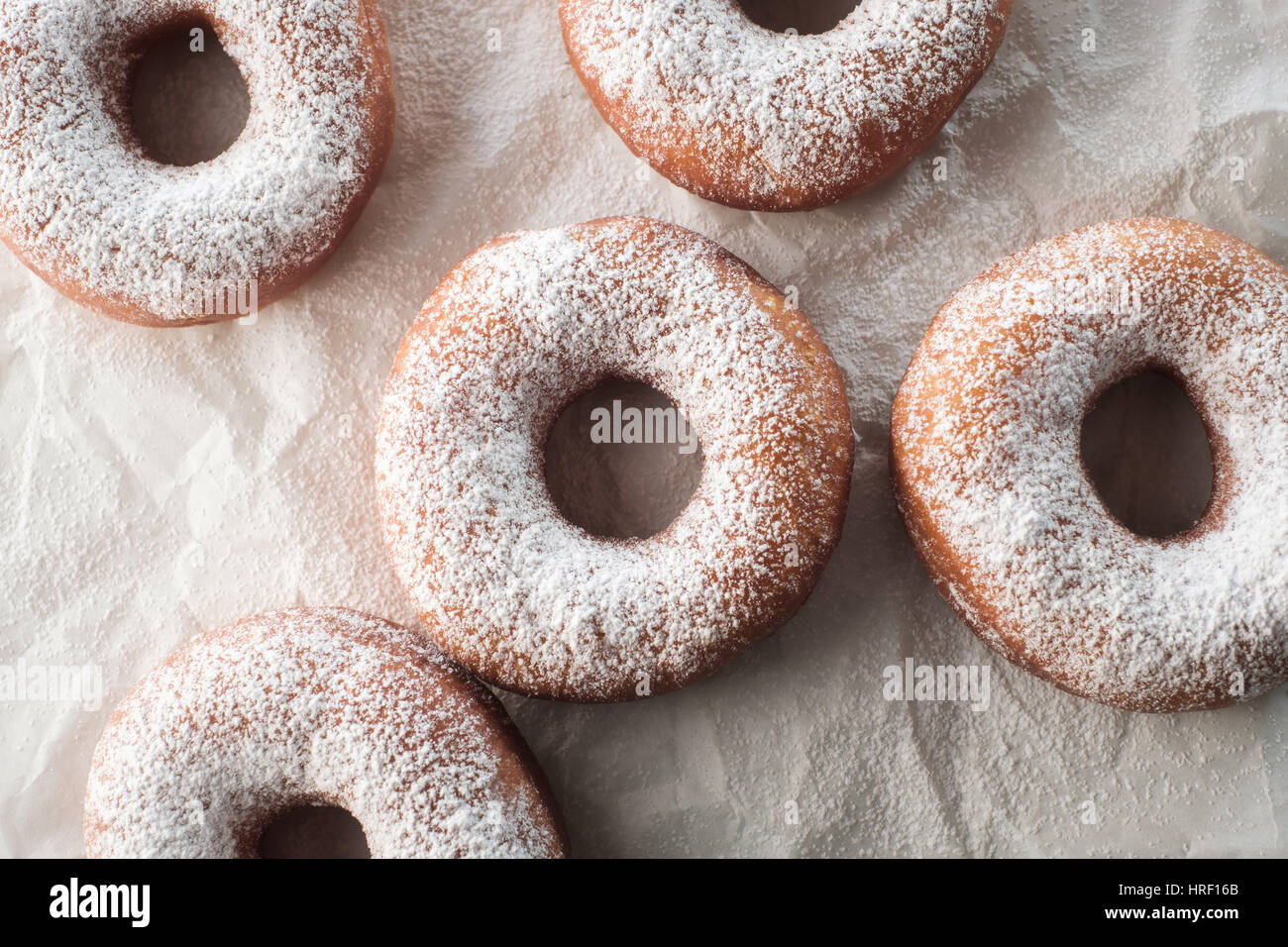 Pulverisierter Zucker Donuts auf weißem Papier Stockfoto