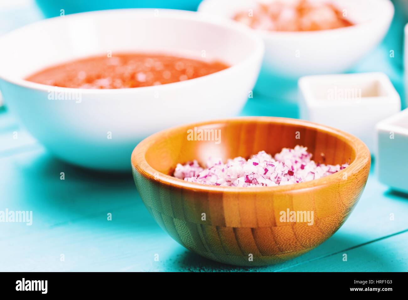 Gehackte rote Zwiebeln und Lebensmittelzutaten auf Türkis Küchentisch Stockfoto