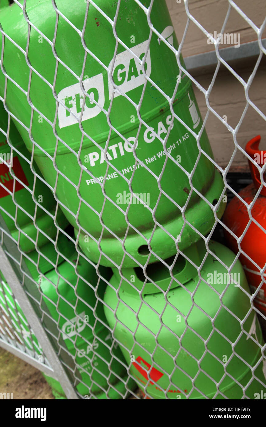 Ein Stapel von Propan-Butan Gasflaschen hinter Netting für Sicherheit. Flo Gas, Calor Gas. Stockfoto