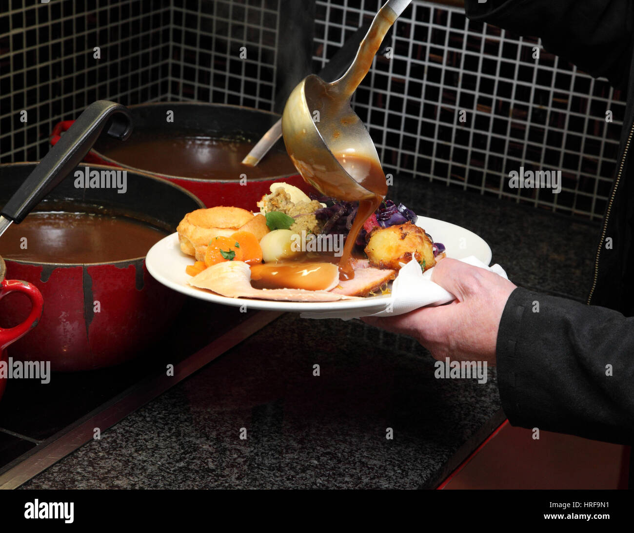 Laden einen Teller mit Gemüse und Soße in einem Toby carvery Pub. Stockfoto