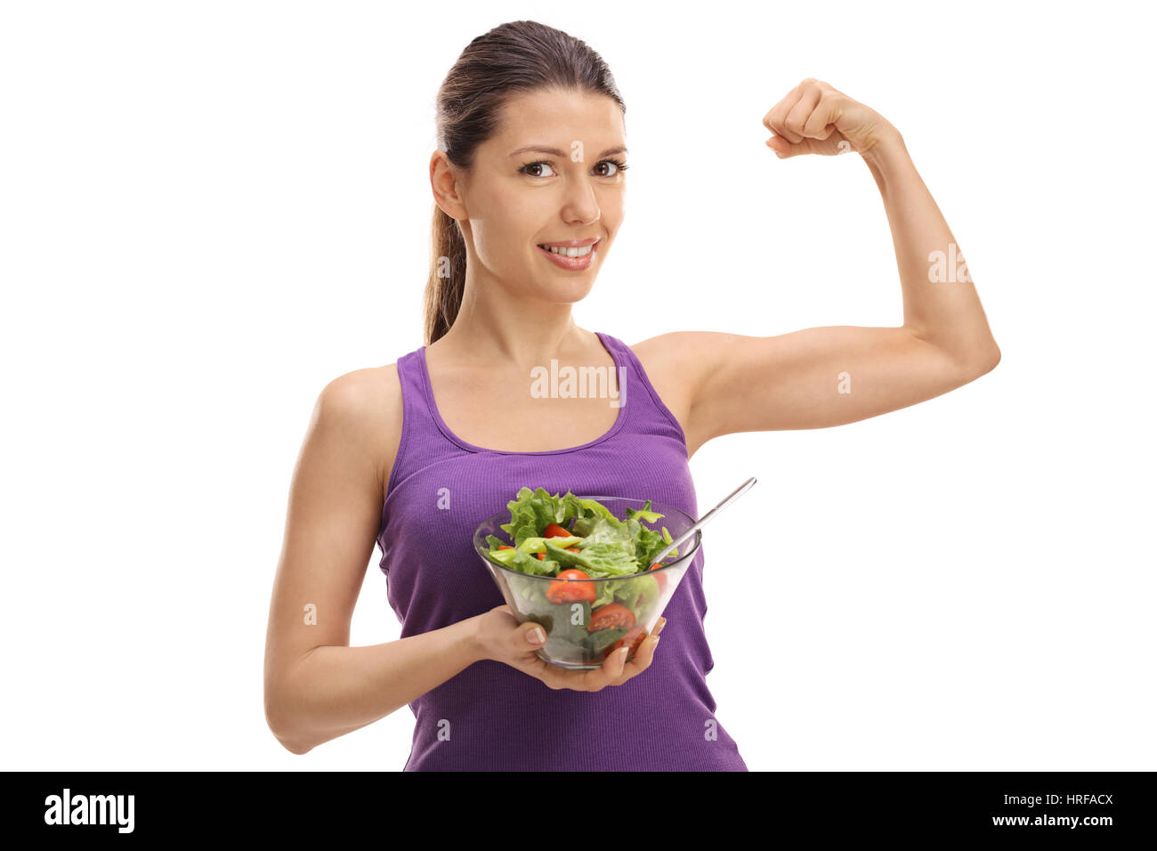 Junge Frau hält einen Salat und beugen ihren Bizeps isoliert auf weißem Hintergrund Stockfoto