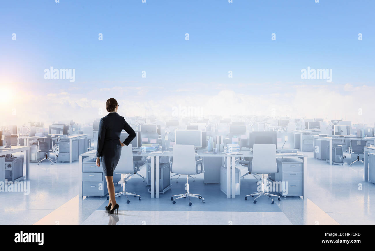 Eine Dame in der formalen Kleidung sucht im Großraumbüro. Mixed-media Stockfoto