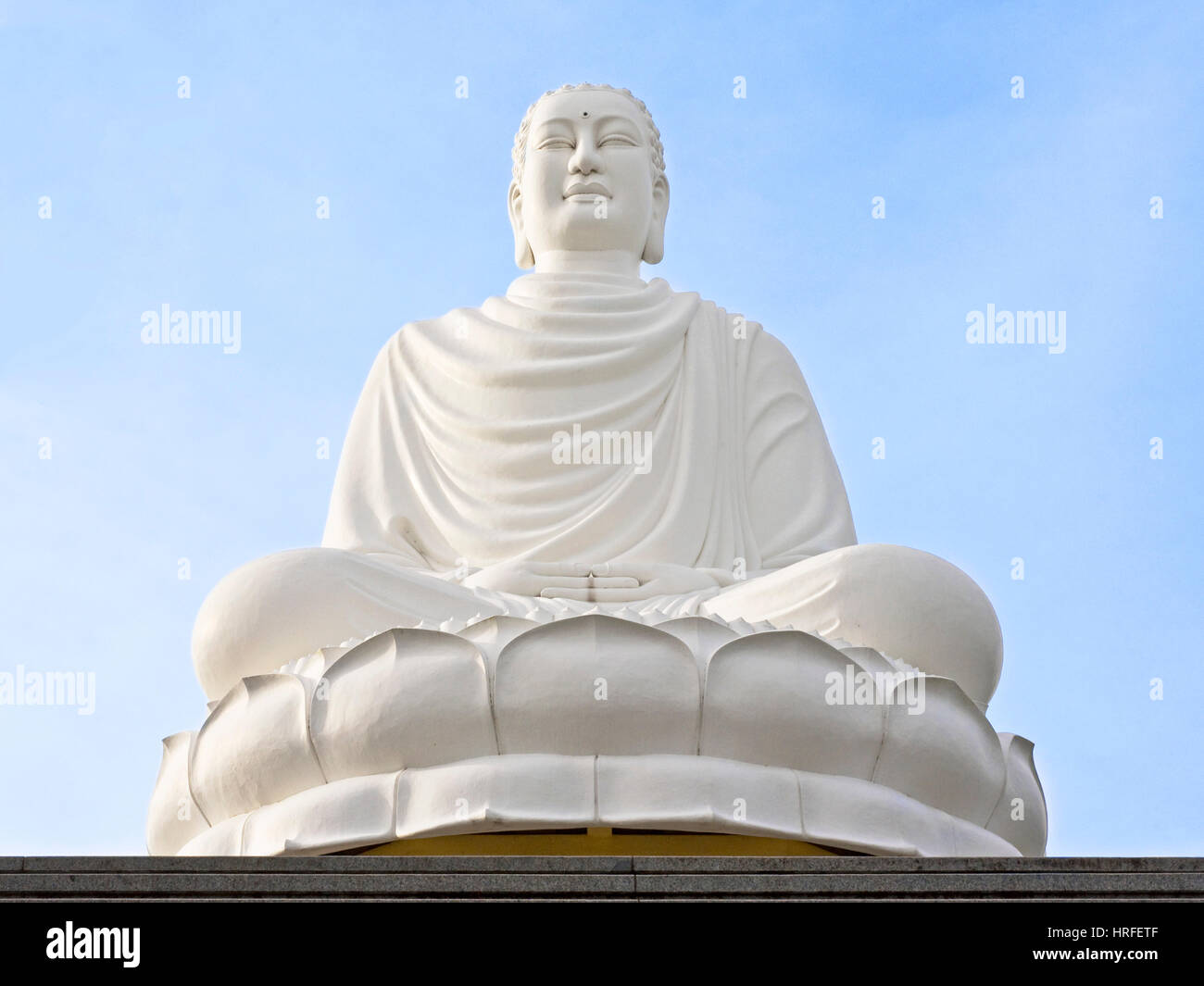 Gautama Buddha in der Nähe der Hai-Duc-Pagode, die auf einem Hügel oberhalb von Nha Trang an einem sonnigen Tag mit blauem Himmel sitzt. Stockfoto