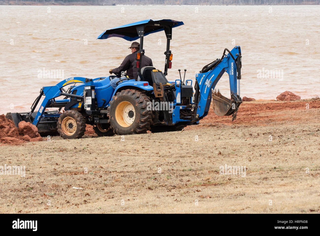 Ein Arbeiter zieht Schmutz und Rock mit einem Wald Groundbreaker BH70-X Baggerlader zu untermauern die Ufer des Sees von Arcadia. Oklahoma, USA. Stockfoto