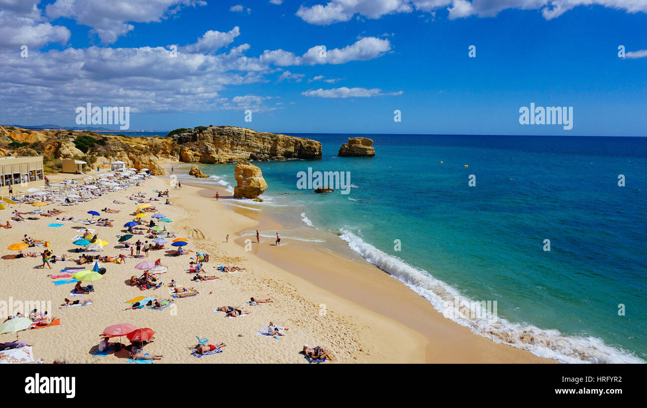 Ein Strand mit Sonnenschirmen und Menschen in Portugal Stockfoto
