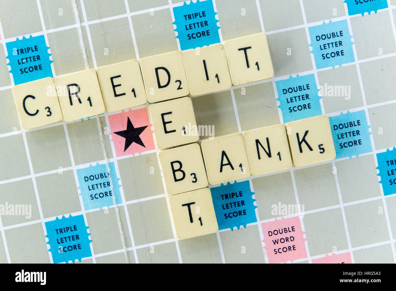 Wörter-Kredite, Schulden und Bank dargelegt auf einem Scrabble-Brett als Finanz- oder Bank-Konzept. Stockfoto