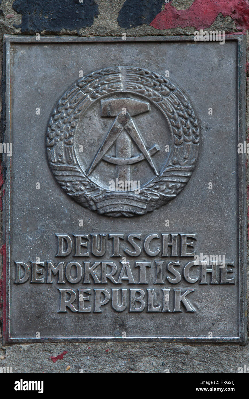 Wappen der Deutschen Demokratischen Republik auf dem Staat Grenze Schild neben dem Eingang zur Mauermuseum (Mauermuseum) in Berlin, Deutschland angezeigt. Stockfoto