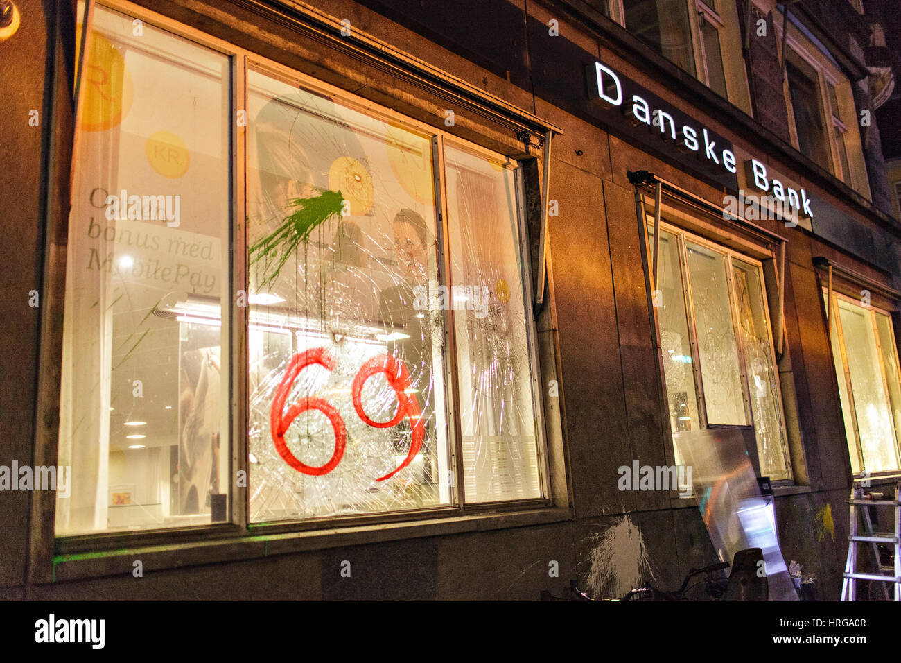 Kopenhagen, Dänemark. 1. März 2017. Linke Aktivisten dauerte die Straßen von Kopenhagen zehn Jahre nach dem Abriss des Jugendhaus Ungdomshuset bei Jagtvej 69. Unter der Aussage "der Kampf geht weiter, nichts vergessen, nichts verziehen" die Aktivisten kollidierte mit der Polizei während des Marsches. Hier Aktivist angegriffen haben, eine Bank, die Zerschlagung der Fenster und gespritzte 69 mit einem Verweis auf Jagtvej 69. Bildnachweis: Gonzales Foto/Alamy Live-Nachrichten Stockfoto