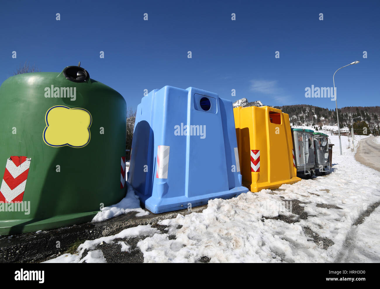 viele Lagerplätze für die Sammlung von Abfällen in einem Bergdorf im Winter mit Schnee Stockfoto