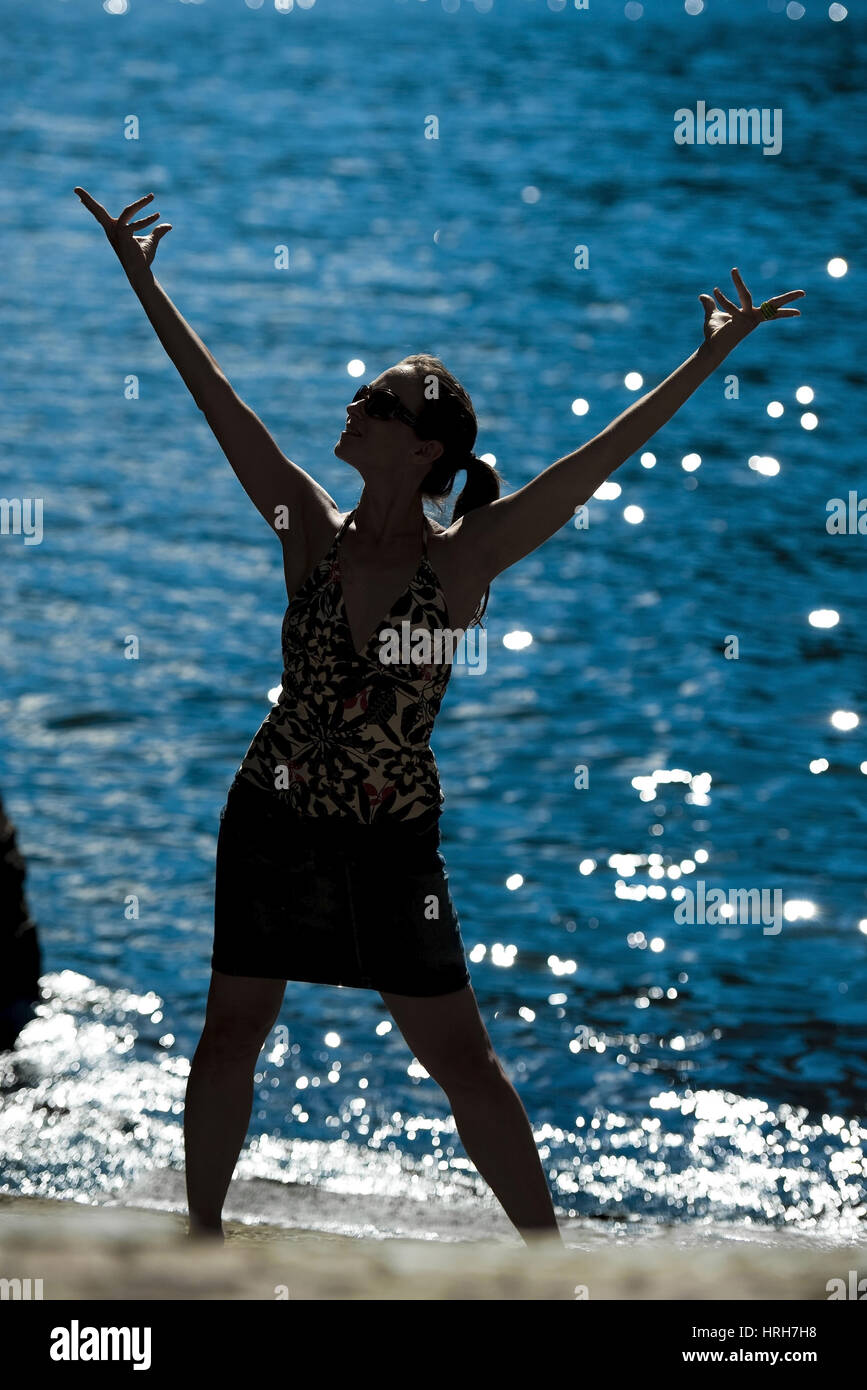 Model freigegeben, Silhouette Einer Frau bin Seeufer, Italienisch - Silhouette einer Frau am Meer Stockfoto