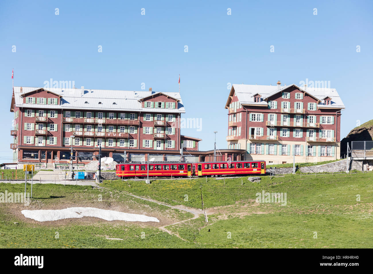 Roten Wagen der Wengernalpbahn Zahnradbahn laufen neben Alpenhotels, Wengen, Berner Oberland, Kanton Bern, Schweiz Stockfoto