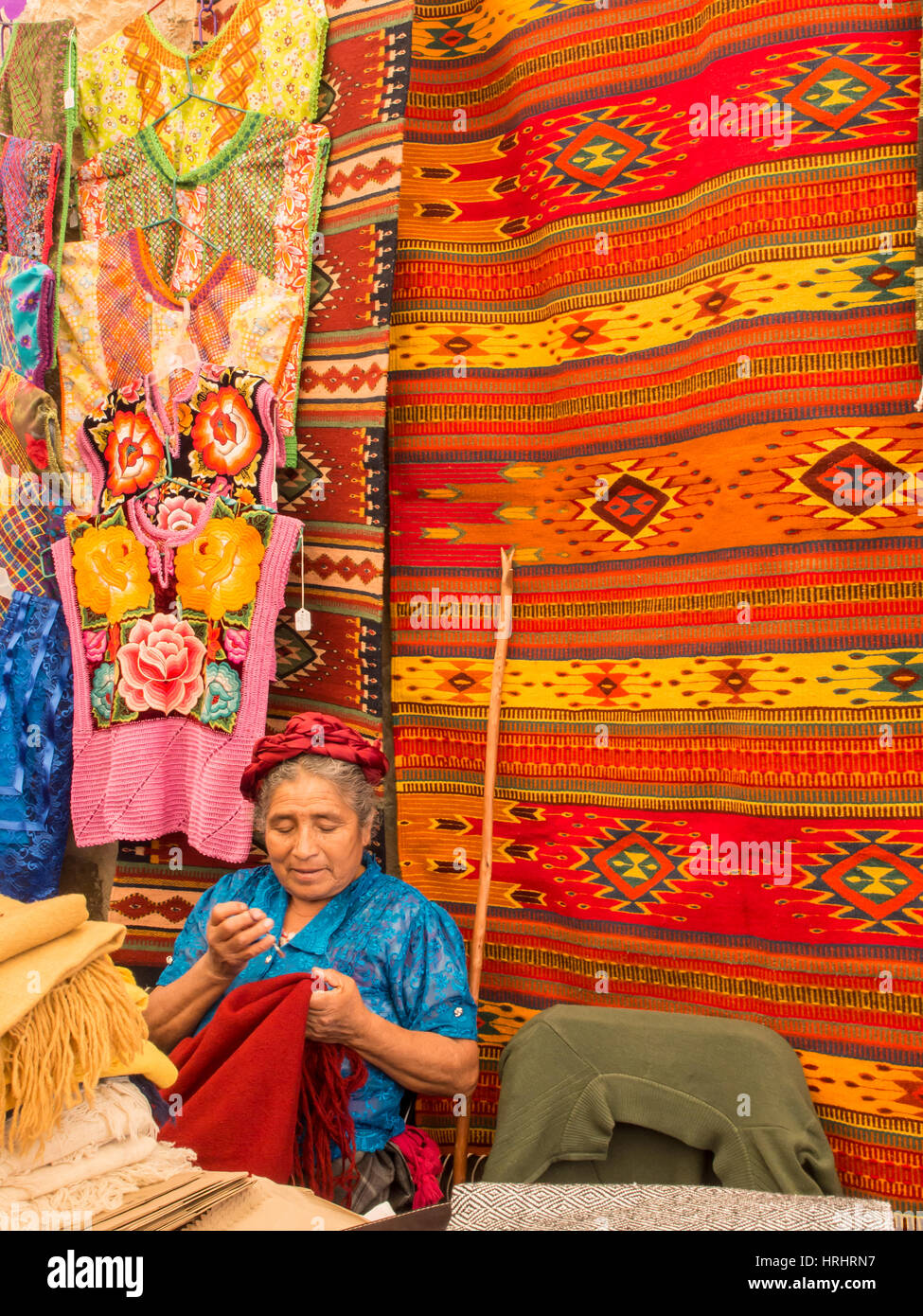 Frau mit Hintergrund handgeknüpfter Teppiche, Oaxaca, Mexiko, Nordamerika Markt Nähen Stockfoto