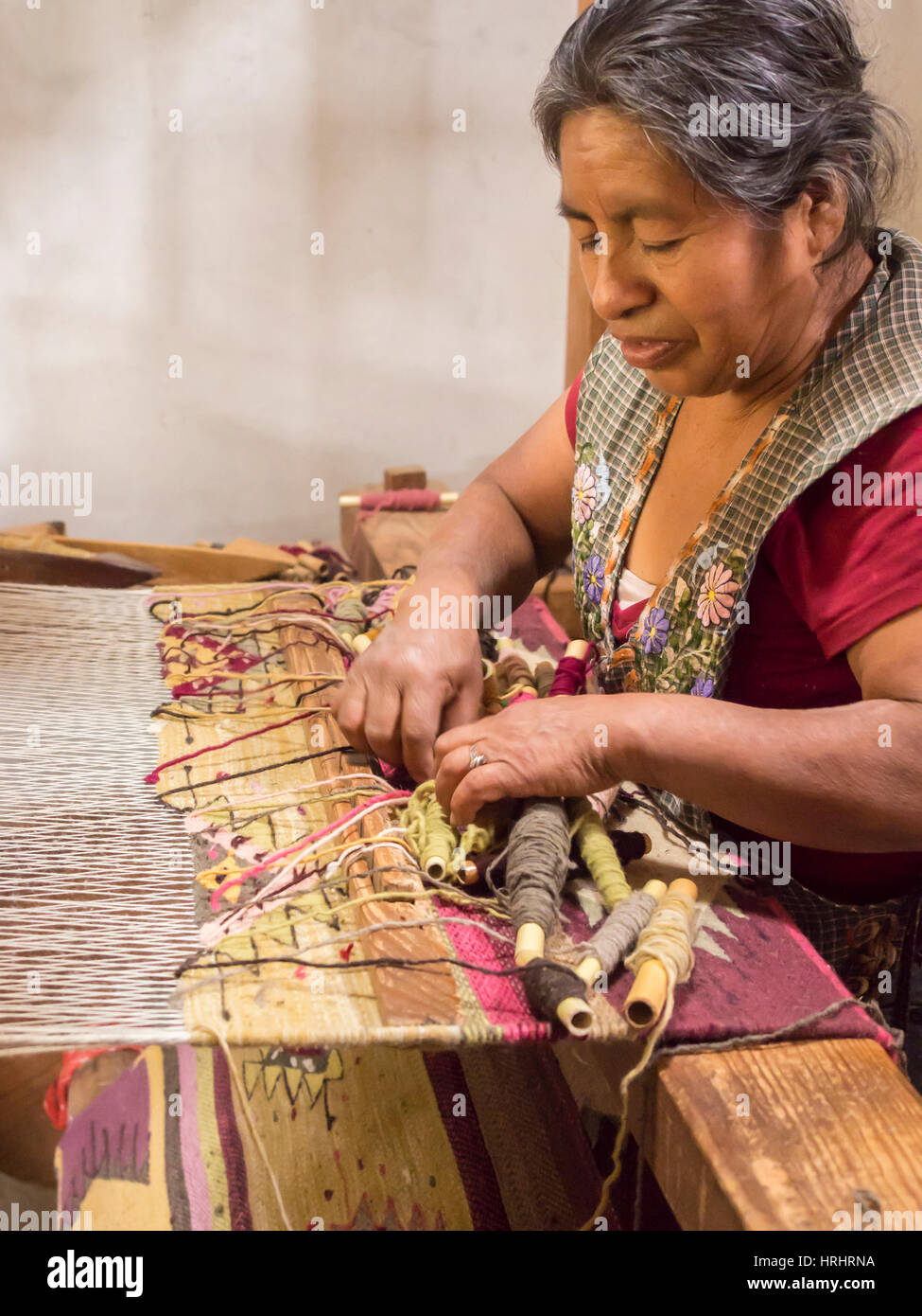 Zapoteken Frau Weben eines Teppichs auf einem Stockwerk Webstuhl in Bauernhaus, Teotitlan del Valle, Oaxaca, Mexiko, Nordamerika Stockfoto