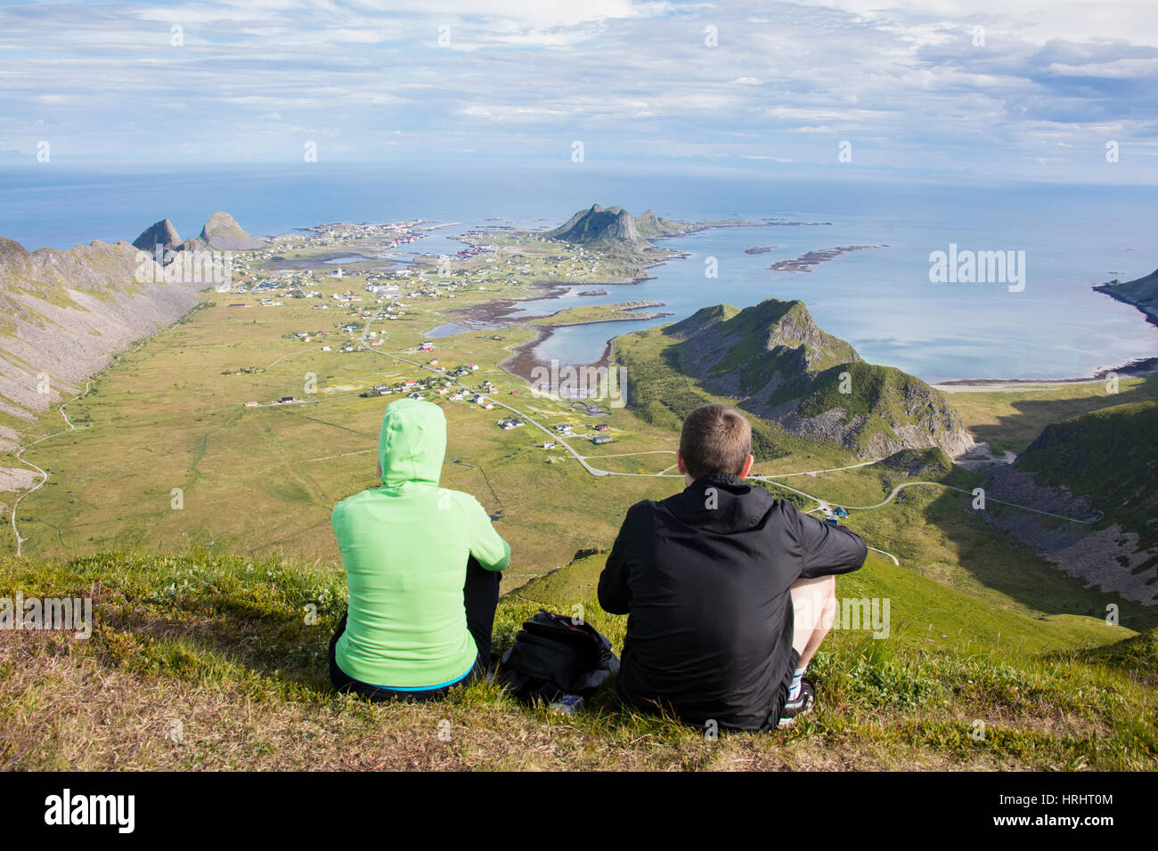 Paar auf Gipfel bewundern Meer umrahmen das Dorf Sorland, Vaeroy Insel, Nordland Grafschaft, Lofoten Inseln, Norwegen Stockfoto