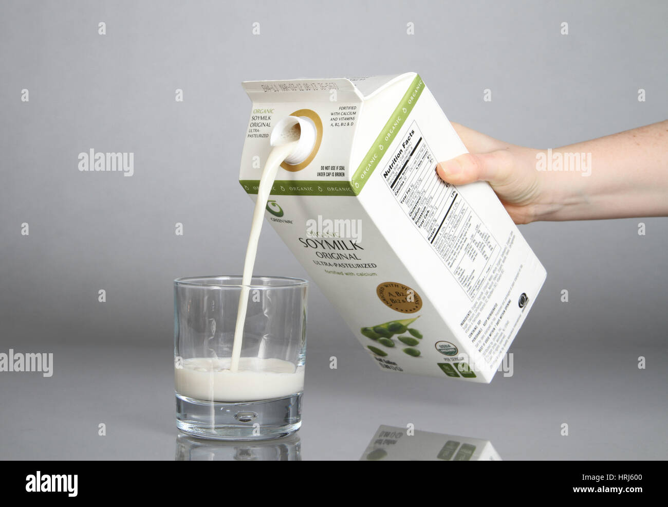 Bio-Soja-Milch in ein Glas gegossen wird Stockfoto