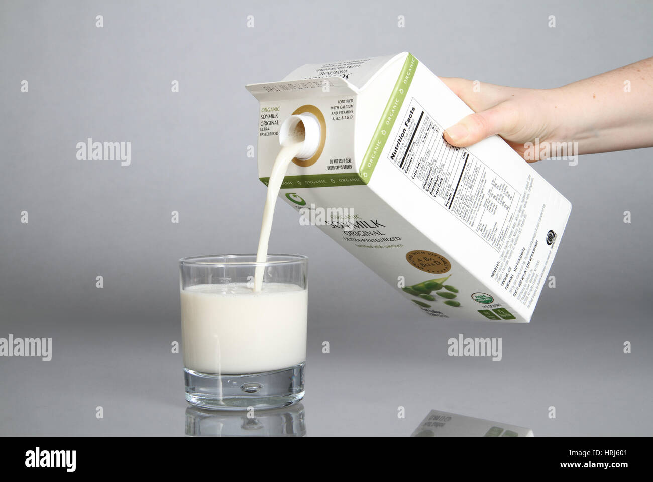 Bio-Soja-Milch in ein Glas gegossen wird Stockfoto