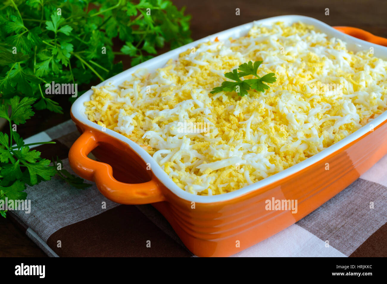 Leichte Frühlingssalat mit gekochtem Gemüse, Eiern und Sardinen in Öl. Slawische Traditionsgericht "Mimosa". Stockfoto