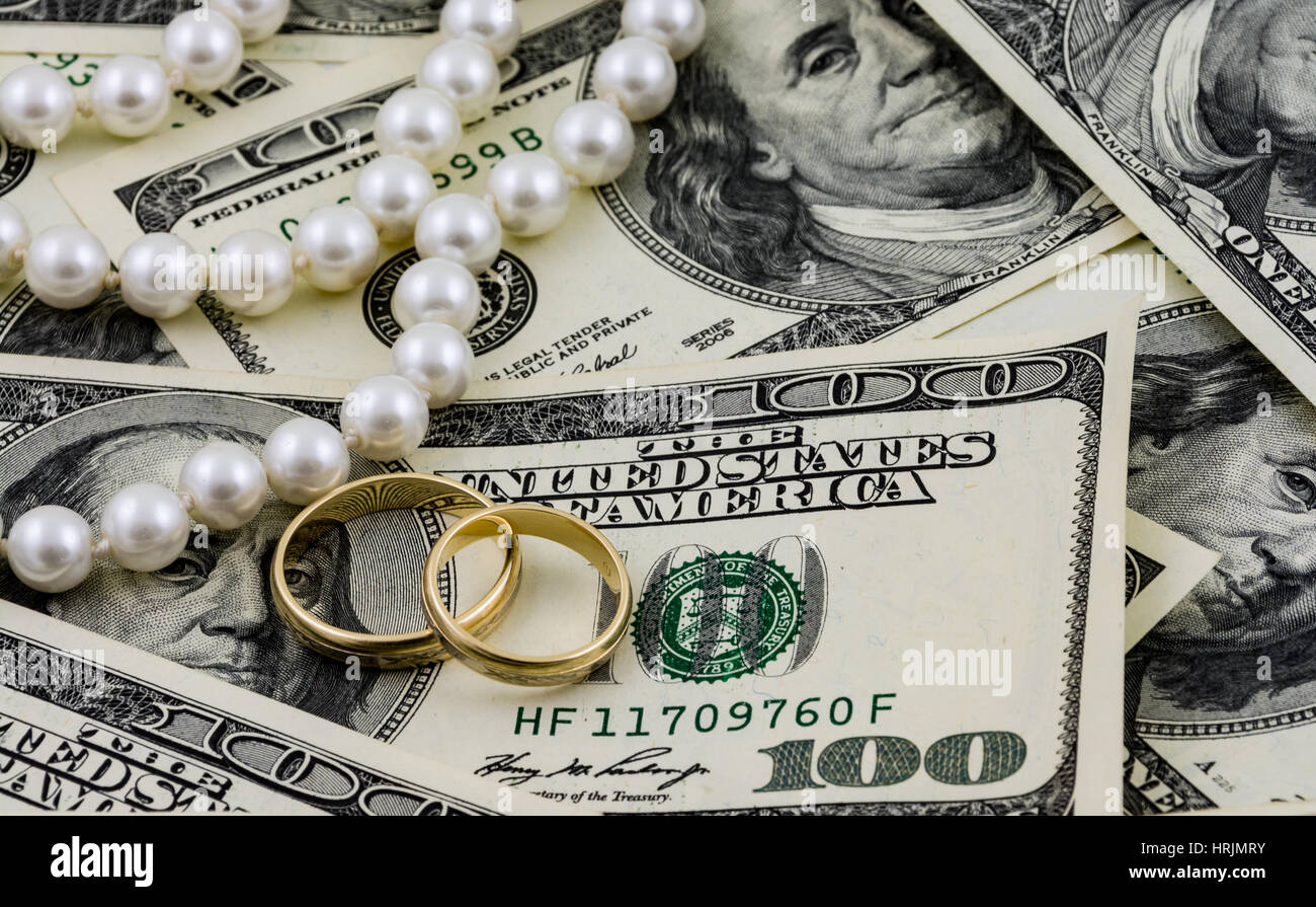 Reichtum-Konzept, US-Dollar-Banknoten, goldene Ringe und echte Perlen Stockfoto