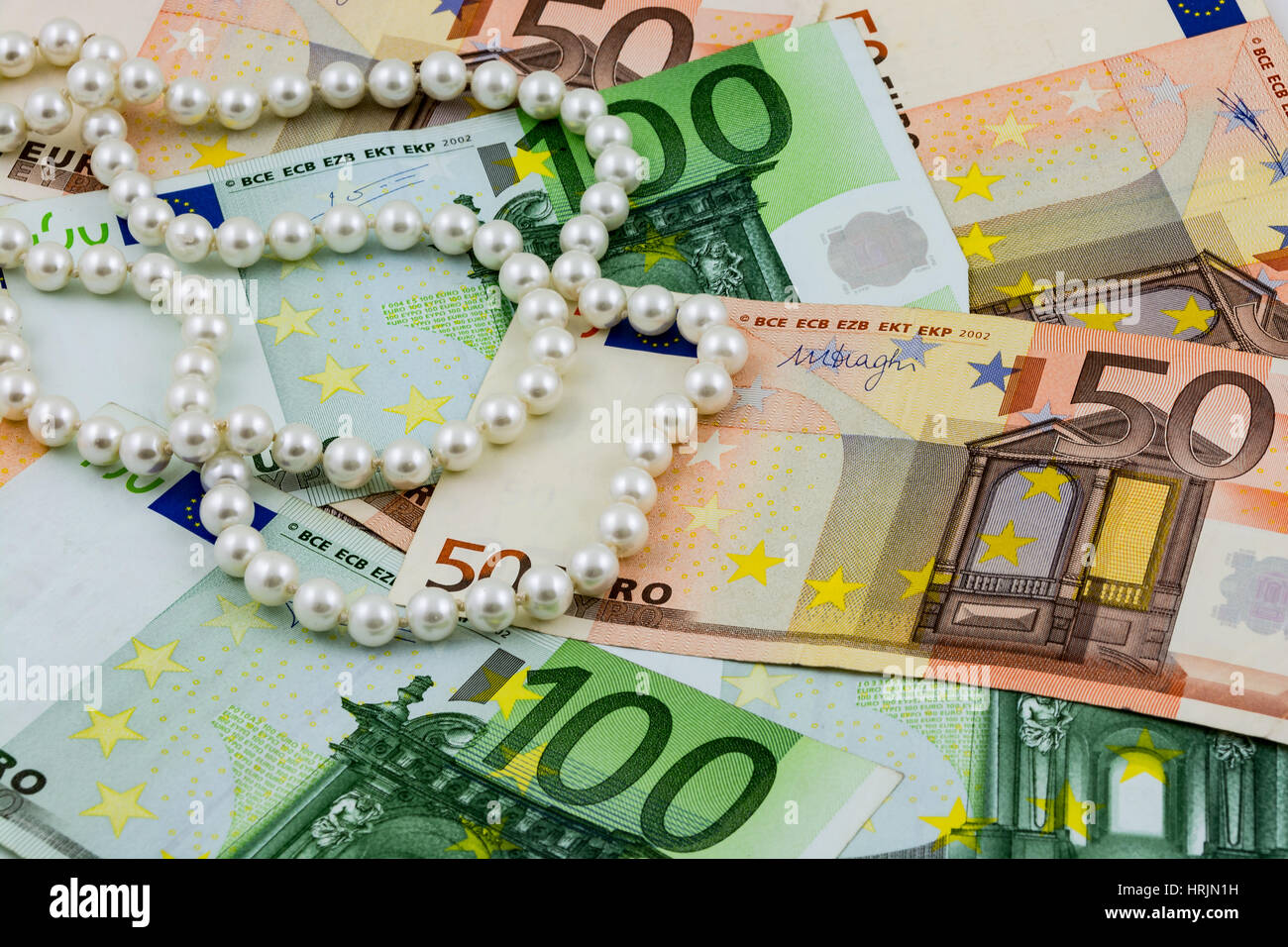 Reichtum, Euro-Banknoten und echte Perlen Stockfoto