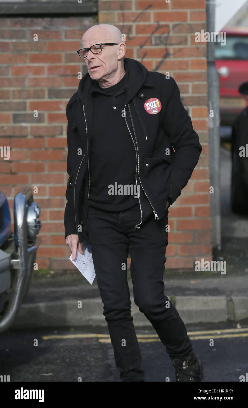 Menschen Sie vor dem Profit Foyle Kandidat Eamonn McCann Ankunft in Modell Grundschule in Derry, seine Stimmabgabe bei den Wahlen zum Northern Ireland Assembly. Stockfoto