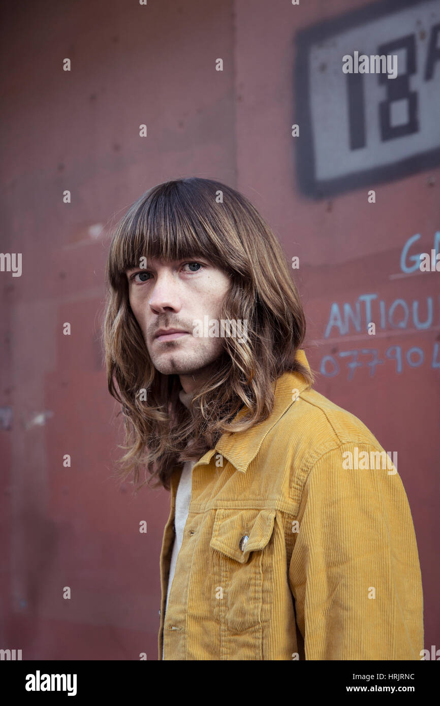 Männliches Model mit langen Haaren und 70er Jahre Stil Stockfoto