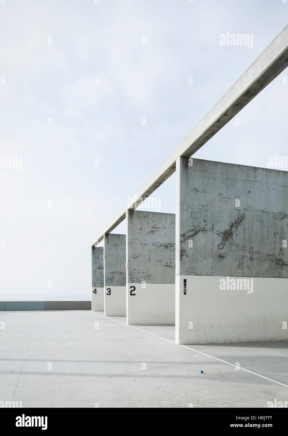 Nummerierte Betonpfeiler in einem Handball-Gericht vor einem blauen Himmel. Stockfoto