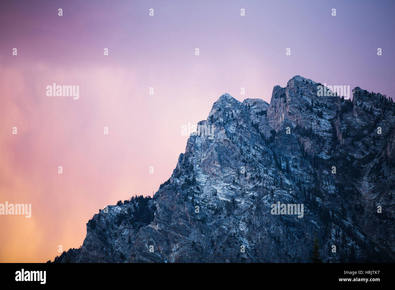 Ein felsiger Berg-Gipfel gegen einen bunten Himmel in der Abenddämmerung. Niedrigen Winkel Ansicht Landschaft und Geologie Stockfoto