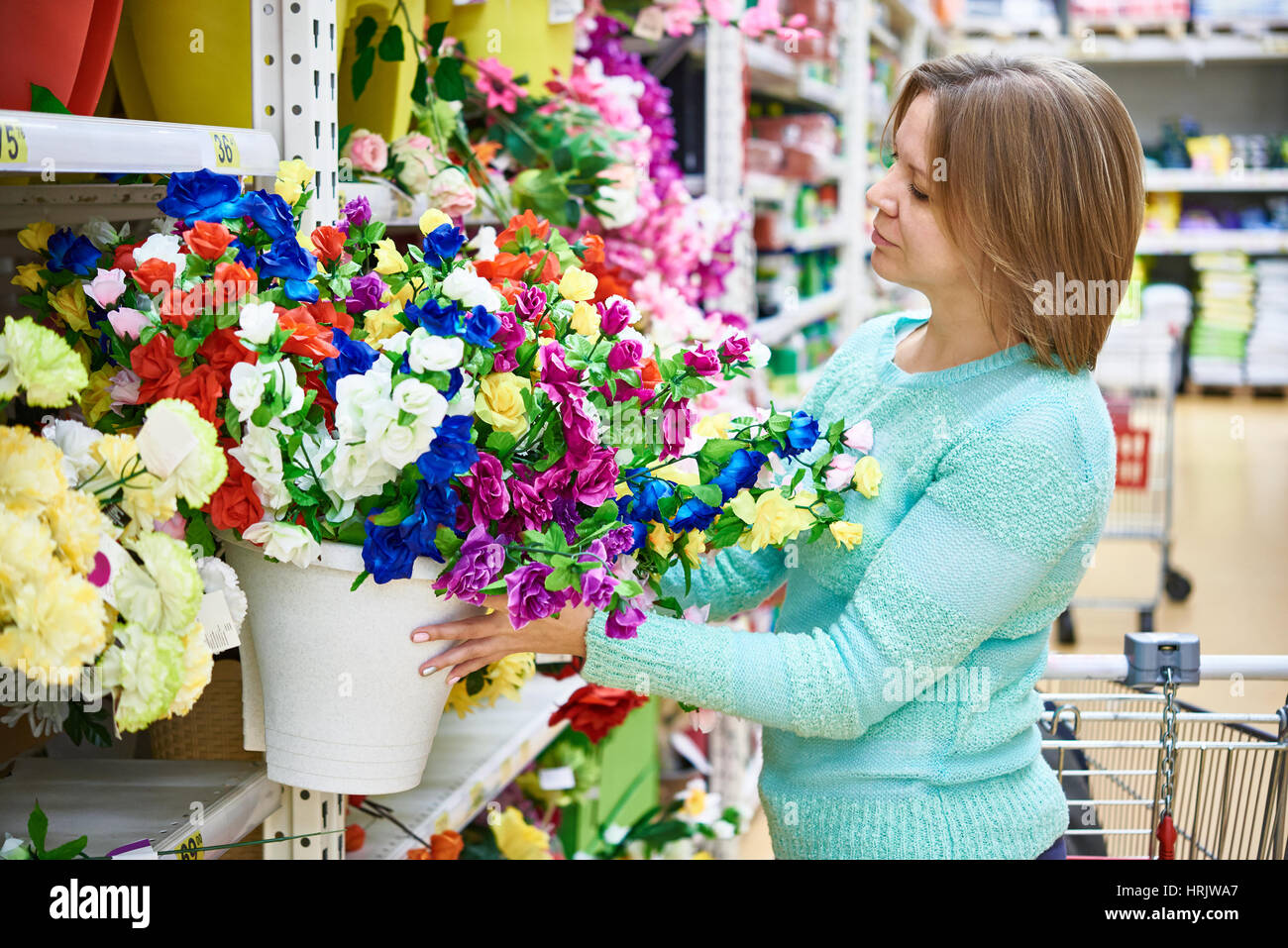 Frau, die Blumen in einem grossen Supermarkt kaufen Stockfoto