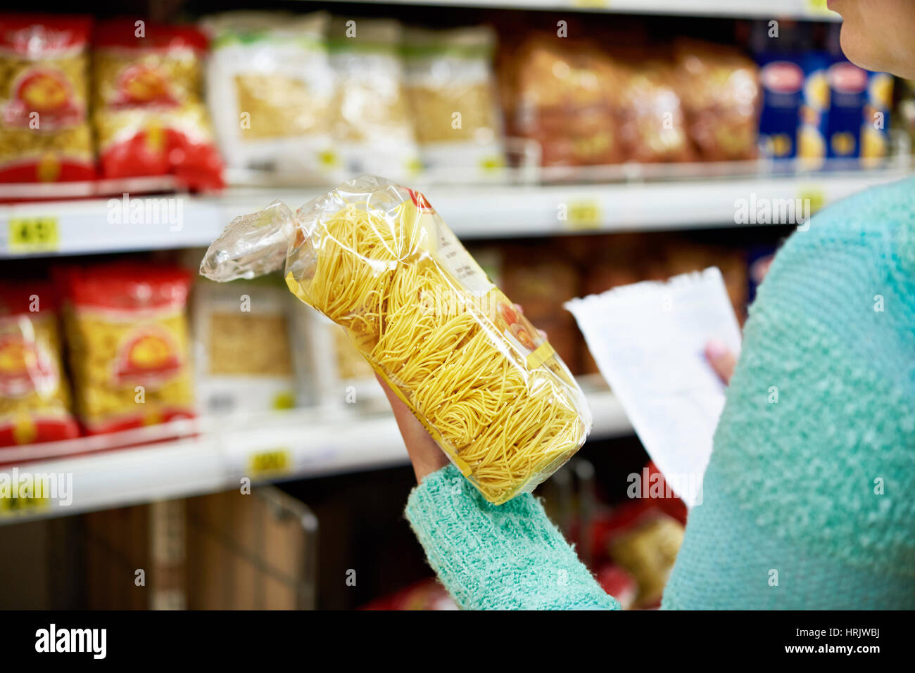 Frau-Käufer mit einem Paket Pasta im shop Stockfoto