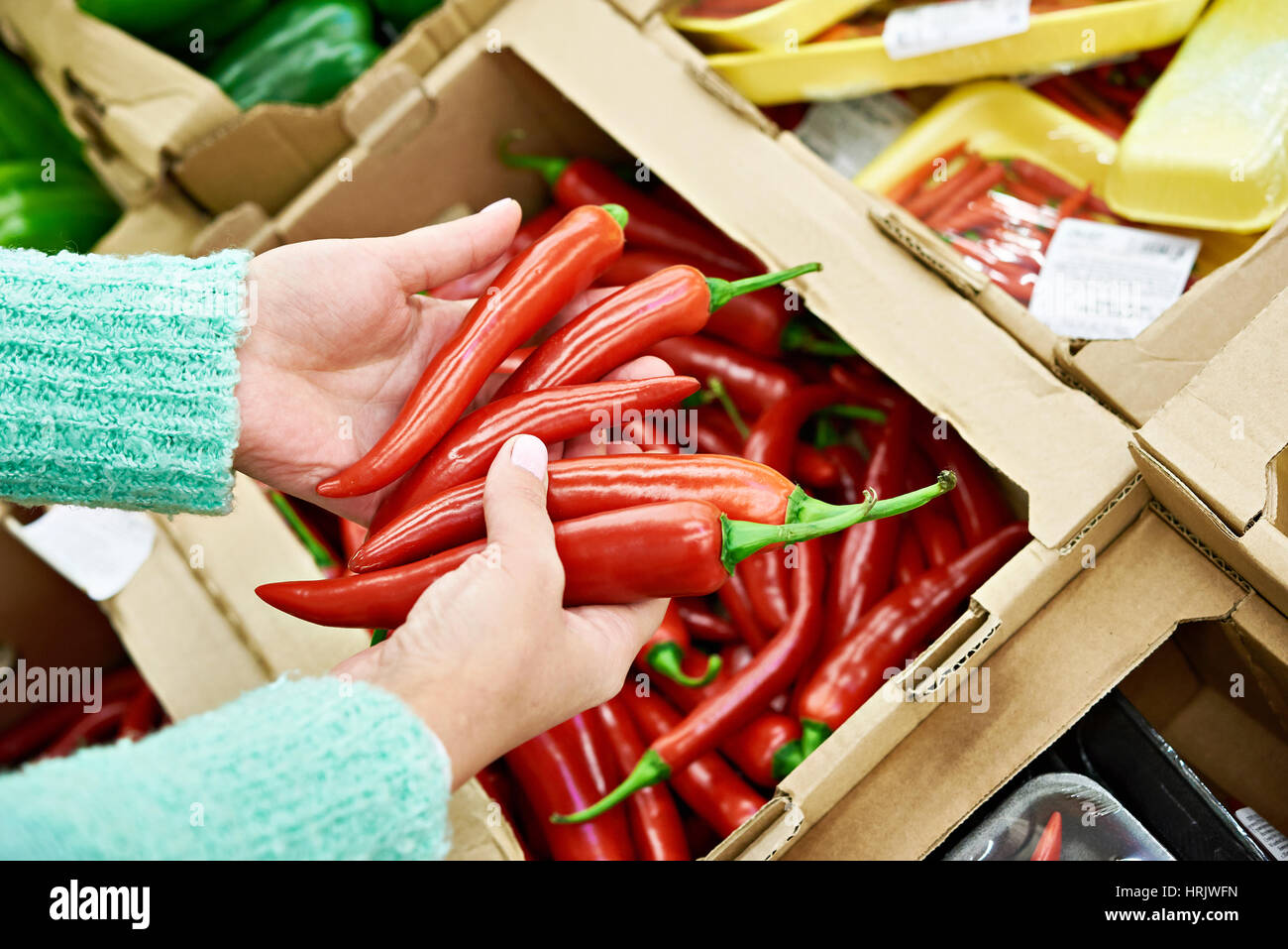 Frau kauft eine heiße rote Paprika im store Stockfoto
